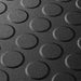 Close up of a Black T Joint interlocking Ecotile floor tile with Raised Disc surface finish